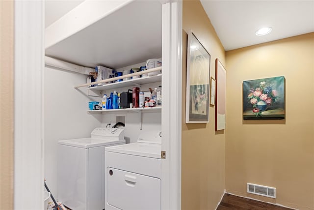 clothes washing area featuring dark hardwood / wood-style flooring and washer and clothes dryer