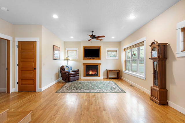 unfurnished living room with ceiling fan and light wood-type flooring