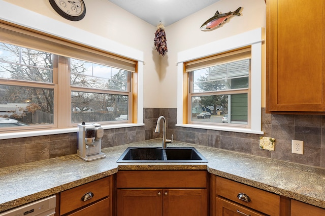 kitchen with a wealth of natural light, decorative backsplash, dishwasher, and sink