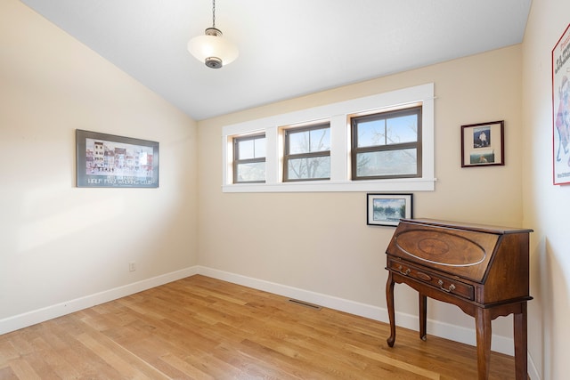 spare room featuring plenty of natural light, light hardwood / wood-style flooring, and lofted ceiling