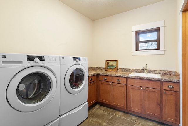 laundry area with washing machine and dryer, cabinets, and sink