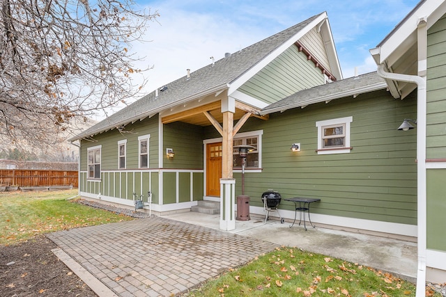 back of property with a patio area and a yard