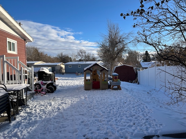 snowy yard featuring a storage shed