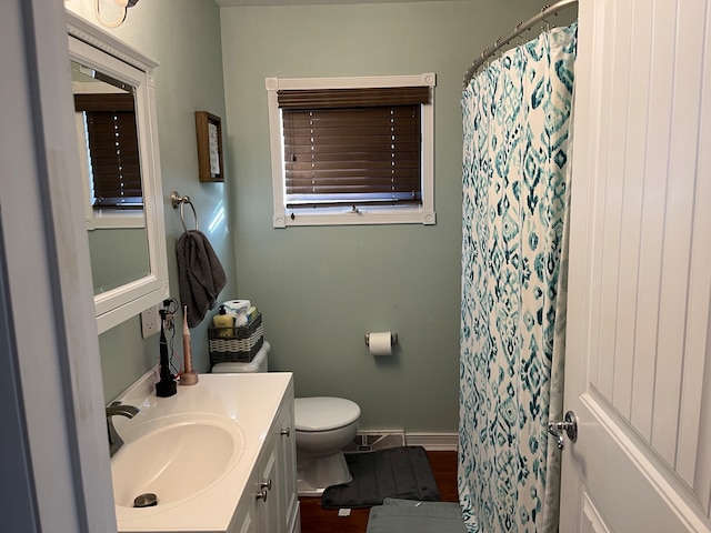 bathroom with curtained shower, vanity, and toilet