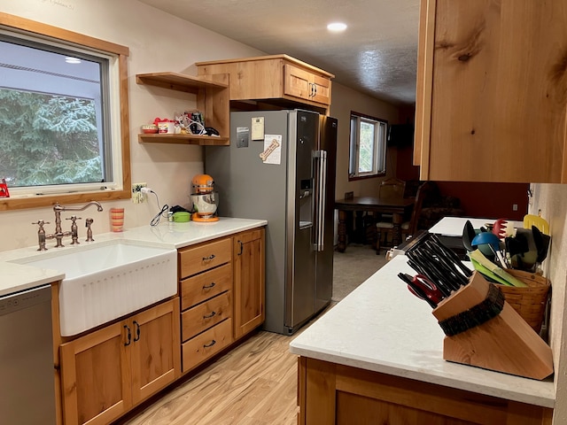 kitchen with dishwasher, light hardwood / wood-style floors, stainless steel fridge with ice dispenser, and sink