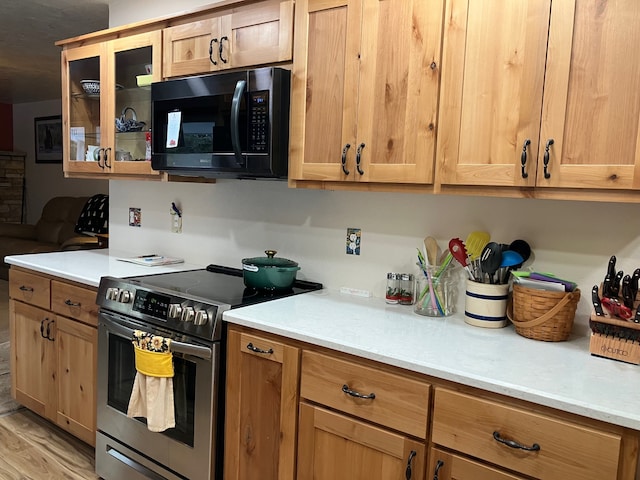 kitchen with electric range and light hardwood / wood-style flooring