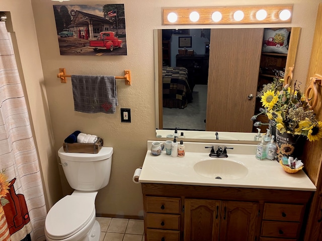 bathroom with tile patterned flooring, vanity, and toilet