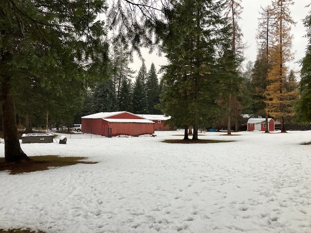 yard covered in snow featuring an outbuilding