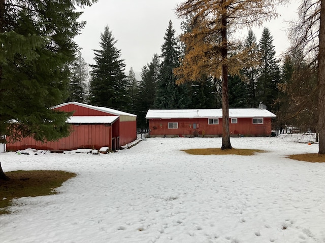 yard layered in snow featuring an outdoor structure