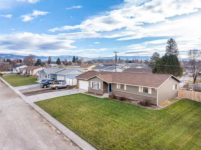 view of front of house featuring a mountain view, a garage, and a front yard