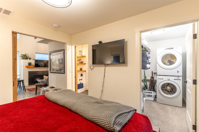 carpeted bedroom with stacked washer and clothes dryer