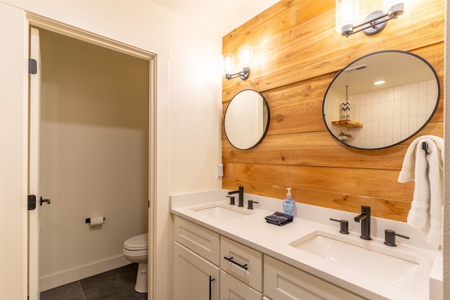 bathroom with tile patterned floors, vanity, toilet, and wooden walls