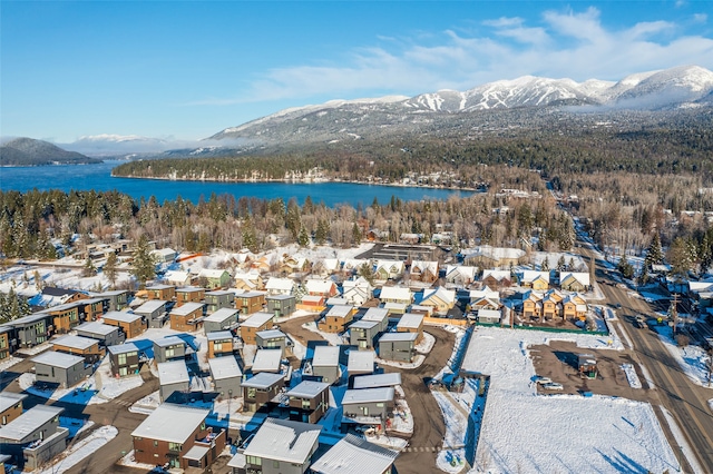 snowy aerial view with a water and mountain view