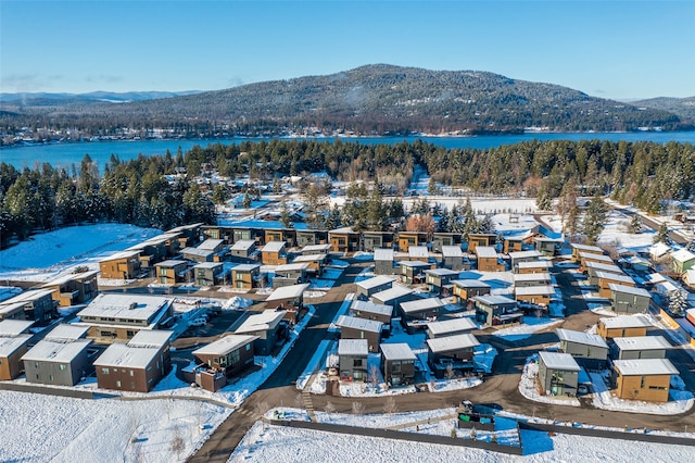 snowy aerial view with a water and mountain view