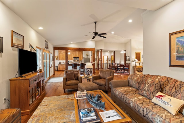 living room featuring ornate columns, ceiling fan, dark hardwood / wood-style flooring, and vaulted ceiling