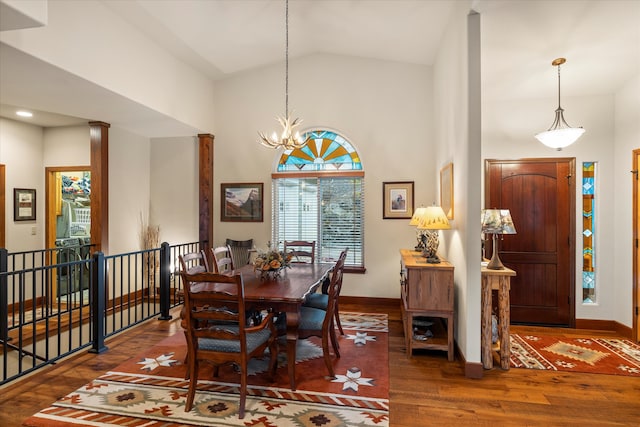 dining area with vaulted ceiling, dark hardwood / wood-style floors, and an inviting chandelier