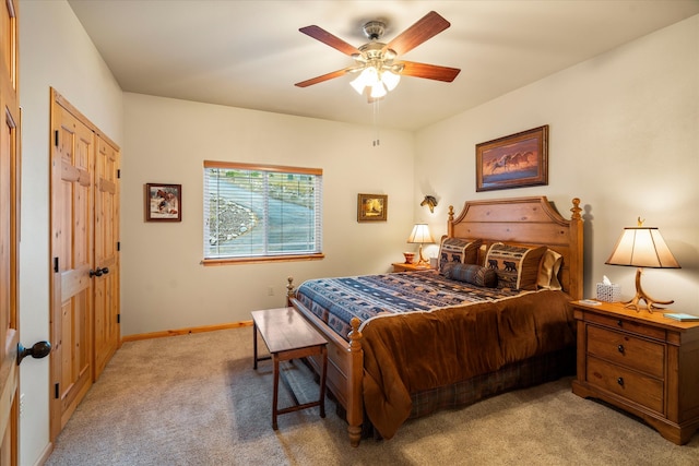 carpeted bedroom featuring ceiling fan and a closet