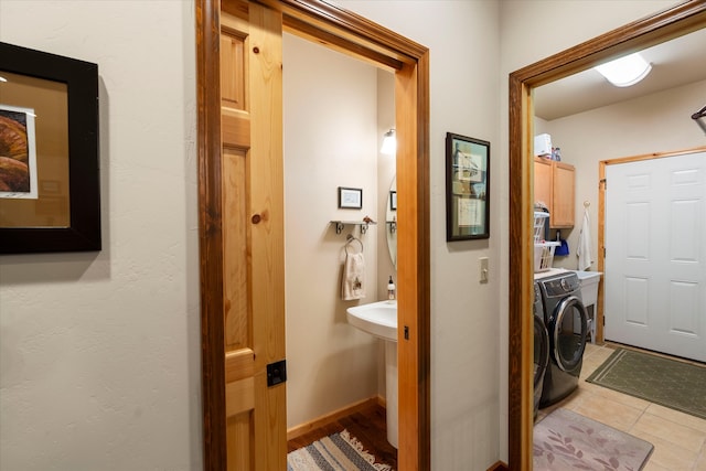 laundry room with cabinets, tile patterned flooring, and washing machine and clothes dryer