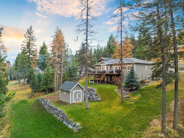 yard at dusk featuring a shed and a wooden deck