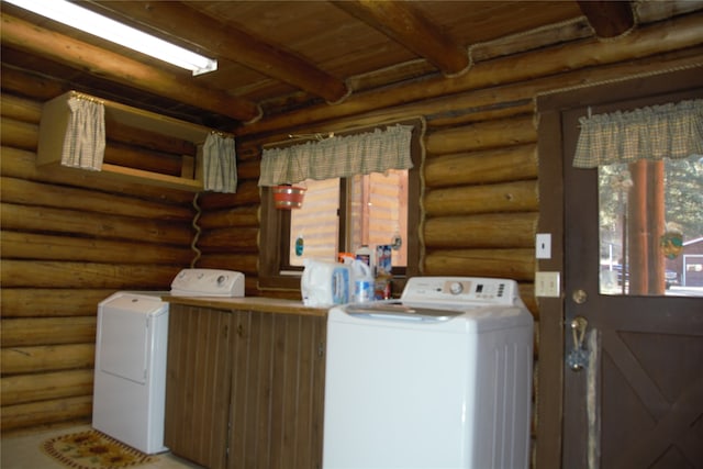 clothes washing area featuring rustic walls, wooden ceiling, and washing machine and clothes dryer