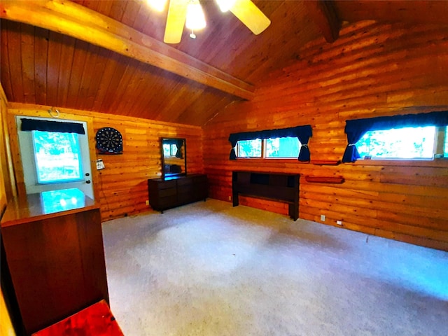 unfurnished living room with ceiling fan, wooden ceiling, vaulted ceiling with beams, carpet floors, and wooden walls