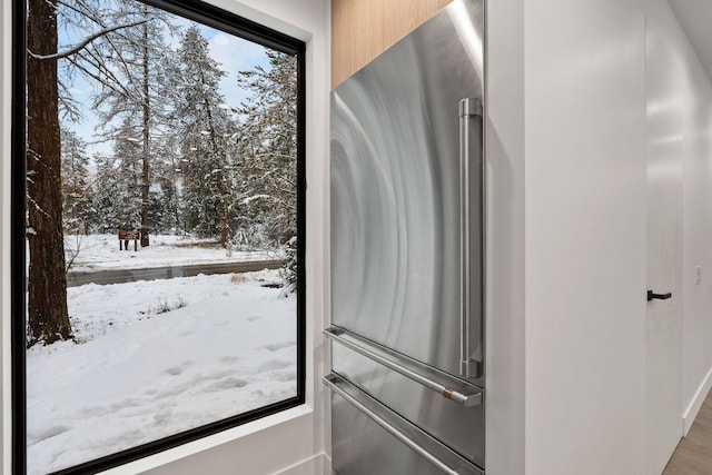 interior details with high end refrigerator and hardwood / wood-style floors