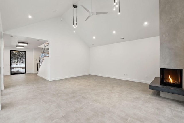 unfurnished living room with ceiling fan, a large fireplace, and high vaulted ceiling