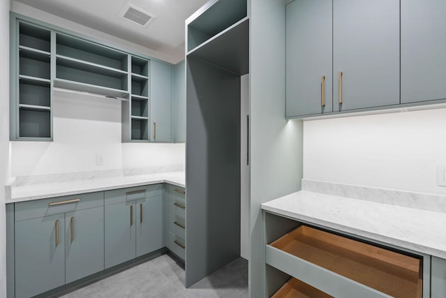 kitchen featuring gray cabinetry and light stone counters