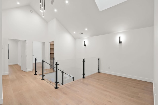 interior space with high vaulted ceiling and light hardwood / wood-style flooring