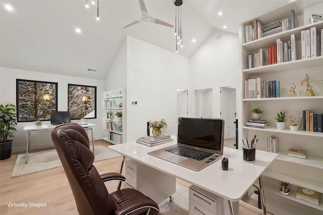 office space with high vaulted ceiling and light wood-type flooring