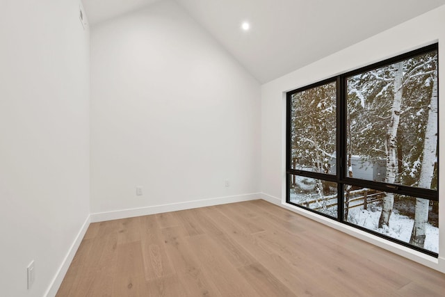 unfurnished room featuring high vaulted ceiling and light hardwood / wood-style flooring