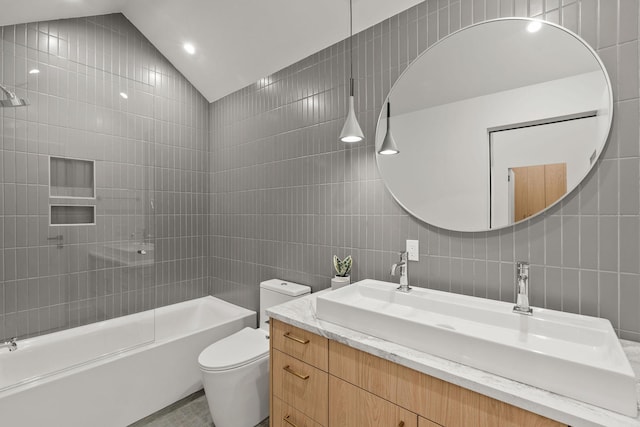 full bathroom featuring vanity, vaulted ceiling, toilet, tile walls, and shower / bath combination