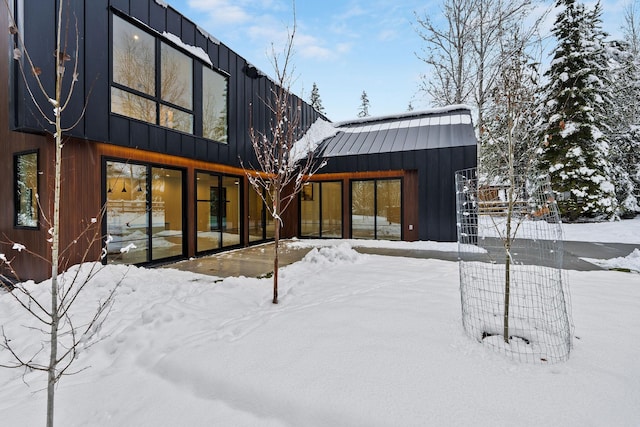 view of snow covered back of property