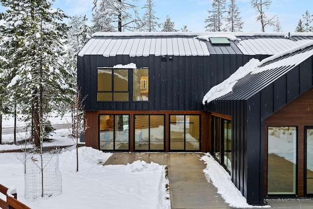 view of snow covered back of property