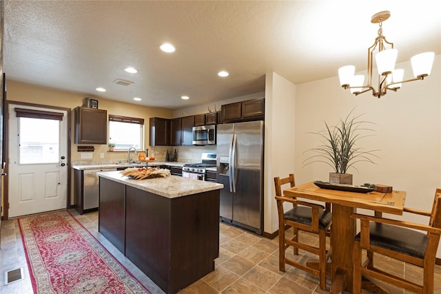 1825 Scott St Unit B, Missoula, MT 59802 - kitchen with appliances with stainless steel finishes, light countertops, dark brown cabinetry, a chandelier, and a sink