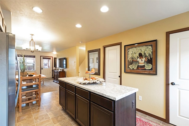 1825 Scott St Unit B, Missoula, MT 59802 - kitchen with freestanding refrigerator, light countertops, a chandelier, dark brown cabinets, and a kitchen island