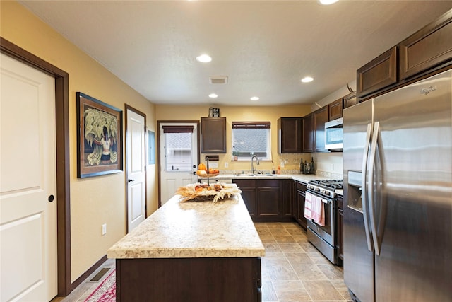 1825 Scott St Unit B, Missoula, MT 59802 - kitchen with stainless steel appliances, a sink, dark brown cabinets, light countertops, and a center island