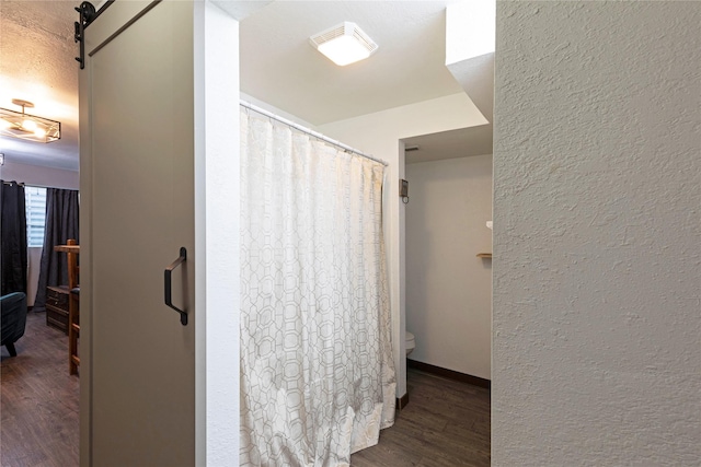 1825 Scott St Unit B, Missoula, MT 59802 - full bathroom with wood finished floors, toilet, a textured wall, and a shower with shower curtain