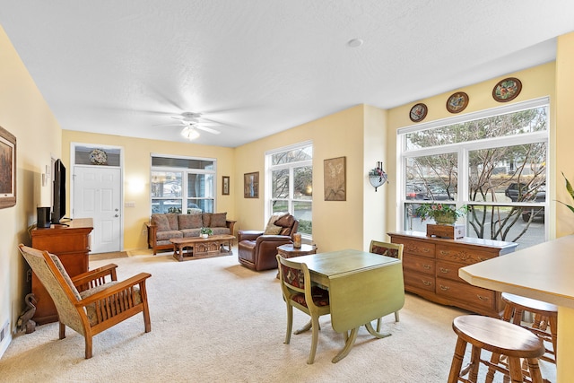 living room with ceiling fan, a healthy amount of sunlight, and light carpet