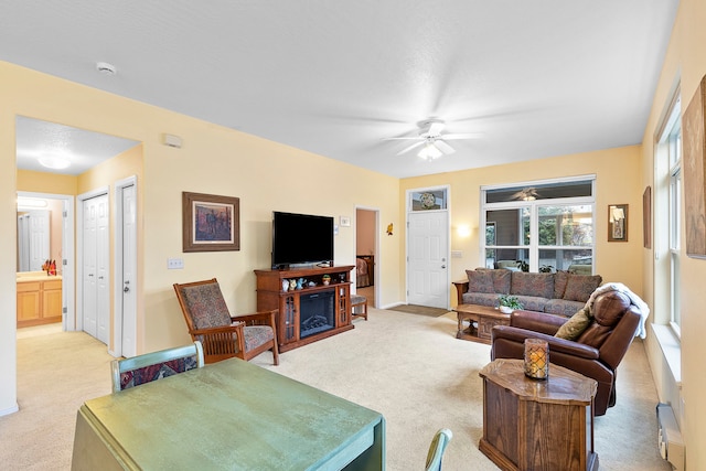 carpeted living room with ceiling fan