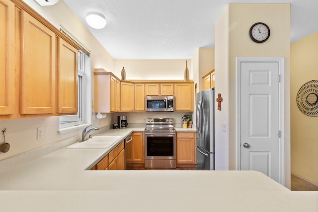 kitchen featuring a textured ceiling, light brown cabinets, sink, and stainless steel appliances