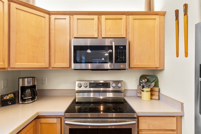 kitchen with light brown cabinetry and appliances with stainless steel finishes