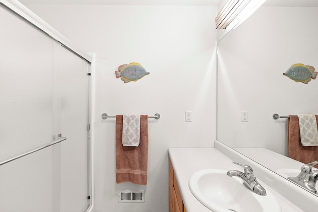 bathroom with vanity and a shower with shower door