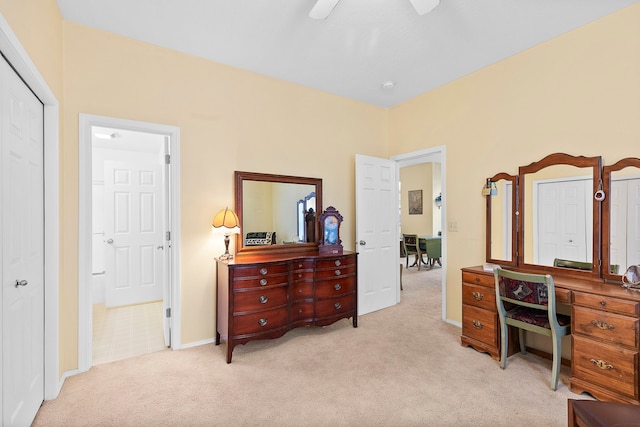 carpeted bedroom with ensuite bathroom and ceiling fan