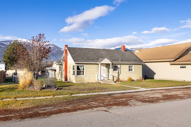 view of front of property with a mountain view and a front lawn