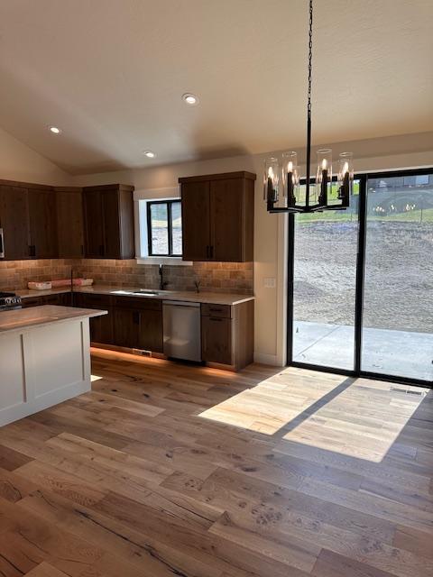 7026 Max Dr, Missoula, MT 59803 - kitchen featuring stainless steel appliances, tasteful backsplash, a chandelier, light wood finished floors, and vaulted ceiling