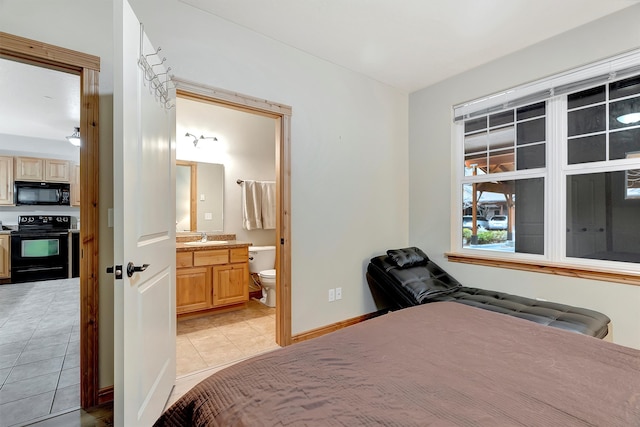 bedroom with light tile patterned floors, ensuite bath, and sink