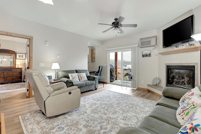 living room featuring ceiling fan, light hardwood / wood-style floors, and an AC wall unit