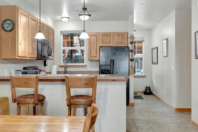 kitchen featuring a kitchen breakfast bar, kitchen peninsula, and pendant lighting