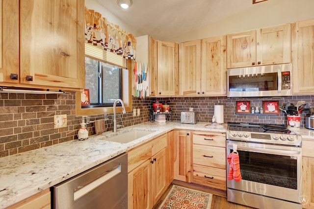 kitchen with sink, light hardwood / wood-style flooring, light brown cabinets, and appliances with stainless steel finishes